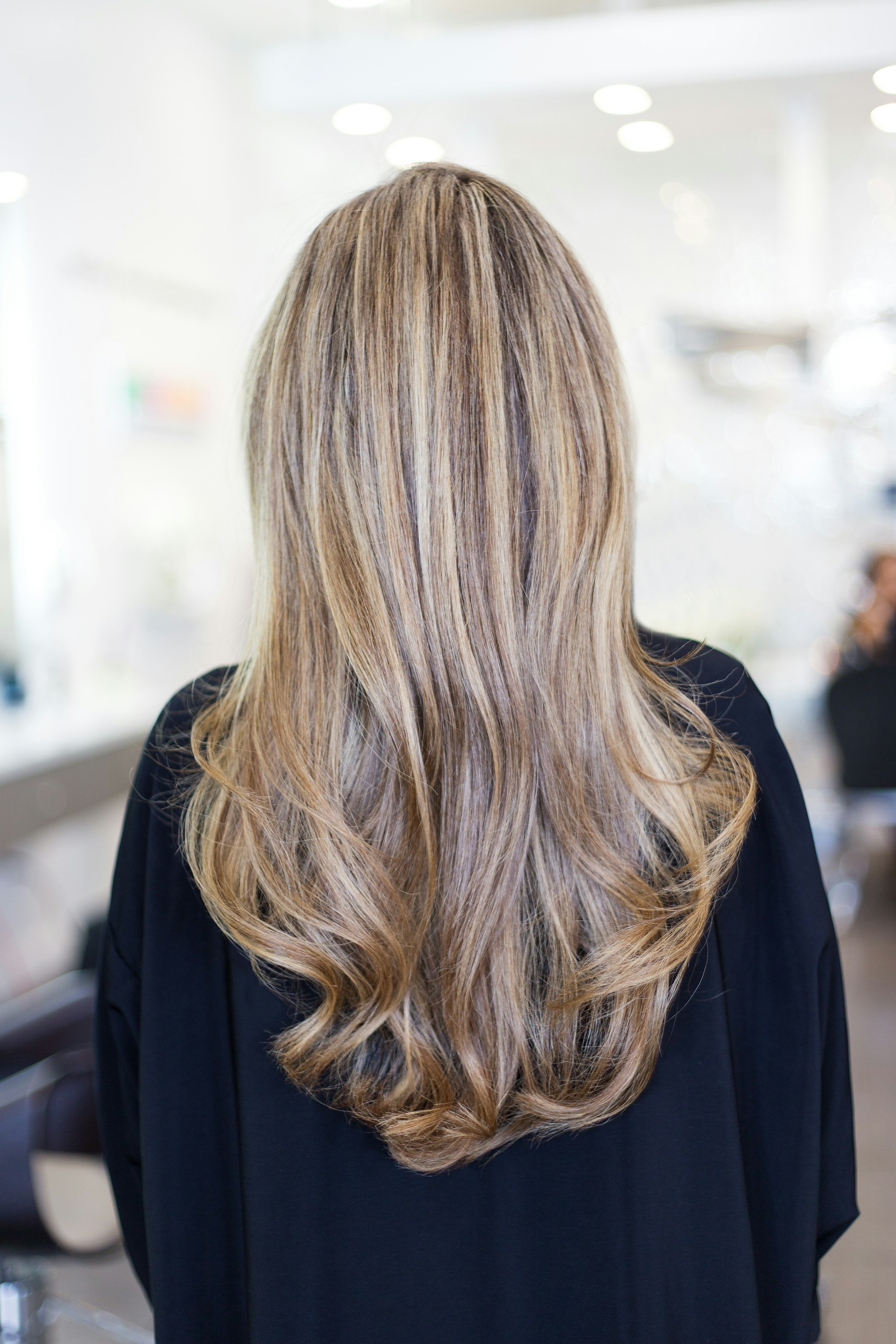 Long, softly waved lived-in blonde hair seen from behind