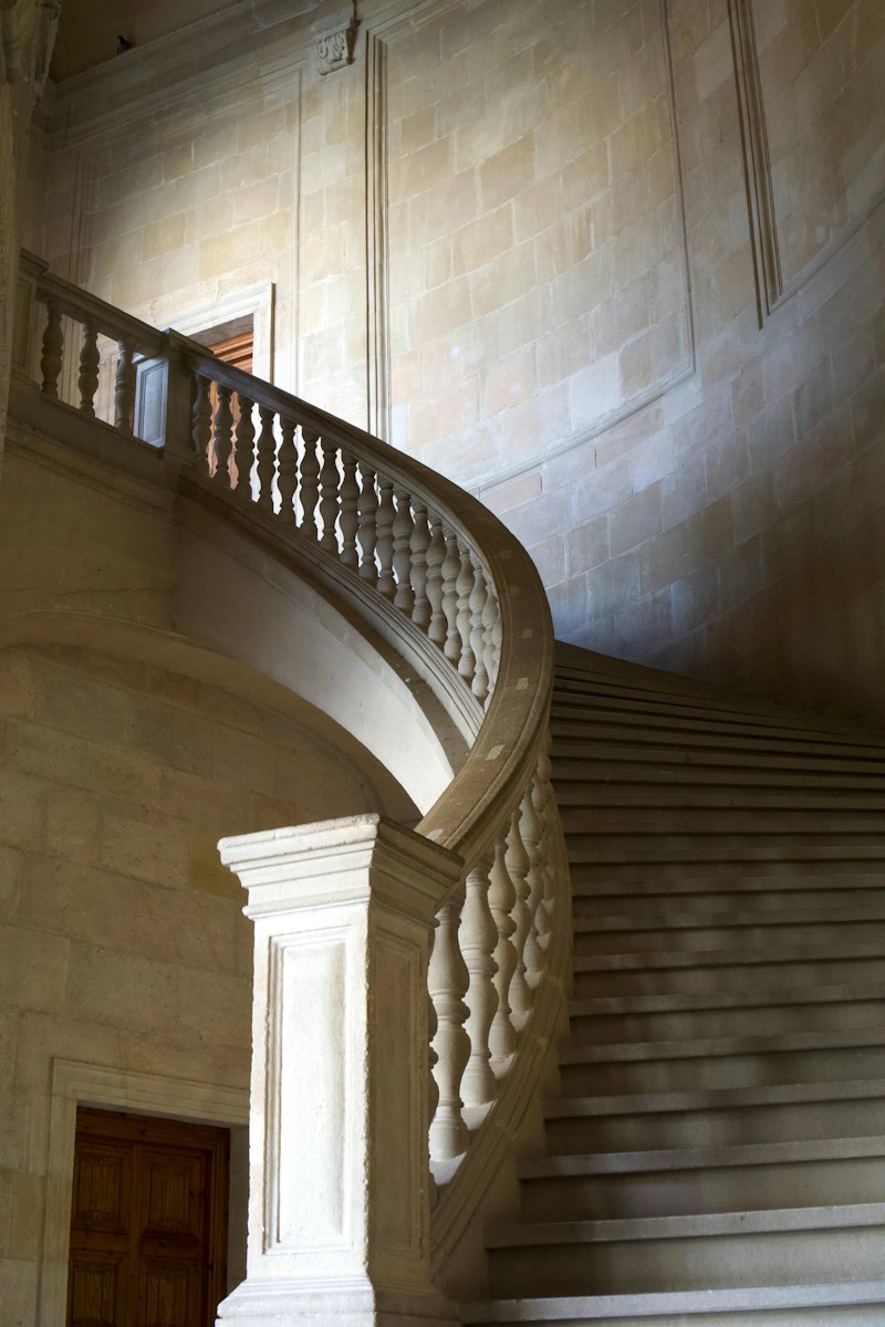 Geschwungene Steintreppe mit Balustrade im weichen Seitenlicht
